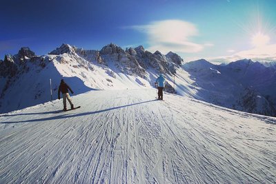 Skiers riding along an exposed ski piste in Austria