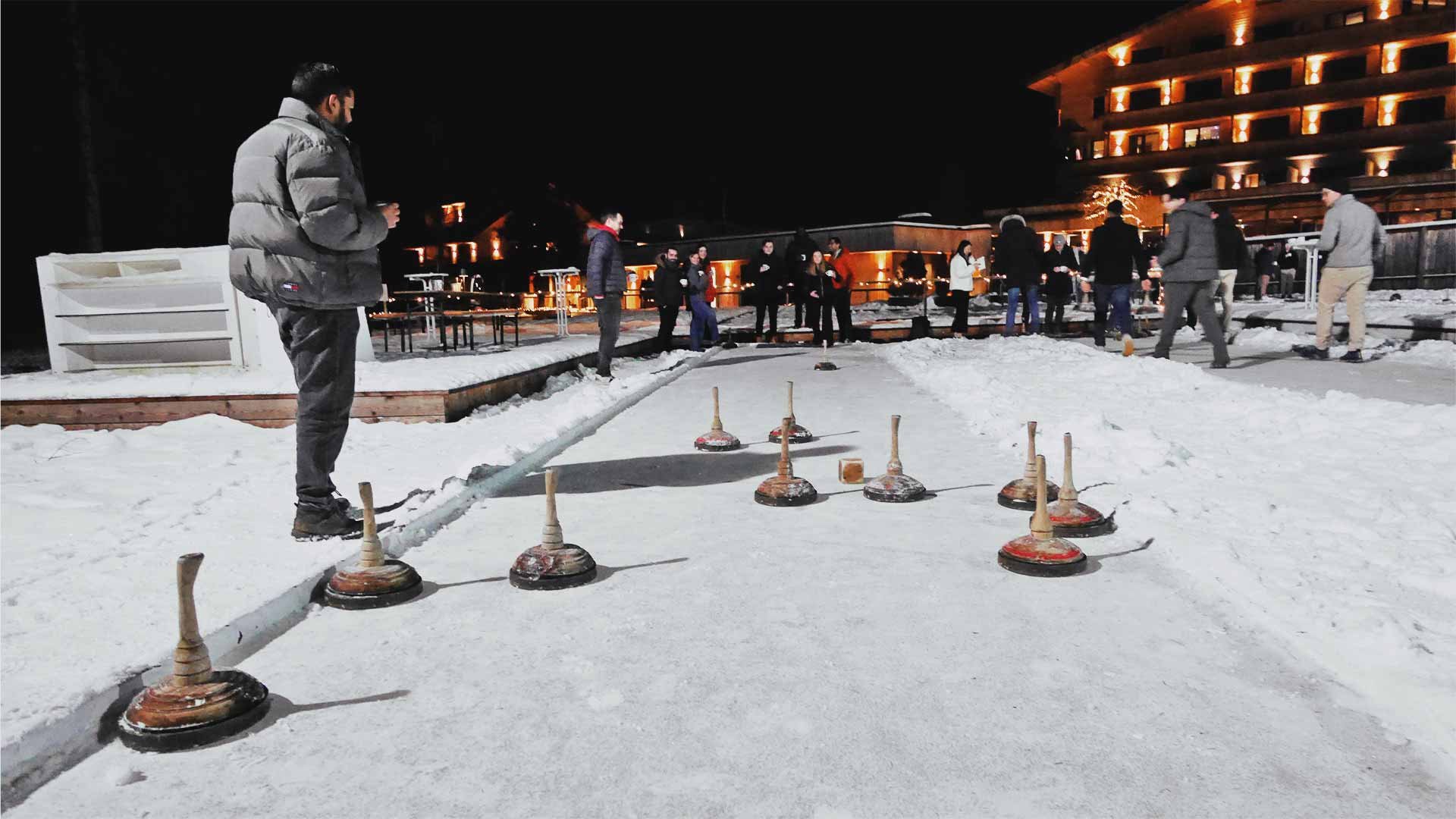 People playing curling on an outdoor rink