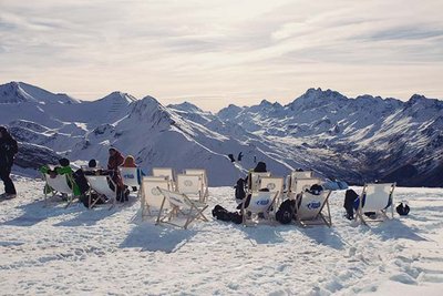 People sitting in deckchairs on a snowy plateau