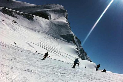 skiers riding across a glacier