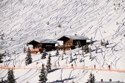 chalet surrounded by ski tracks in the snow