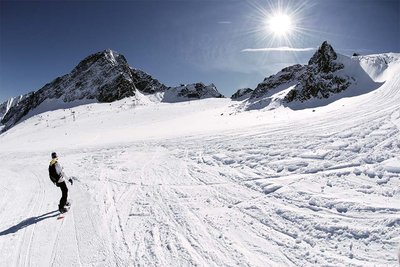 Snowboarder riding on an empty ski piste