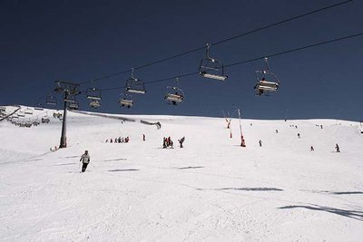 skiers riding down a ski piste